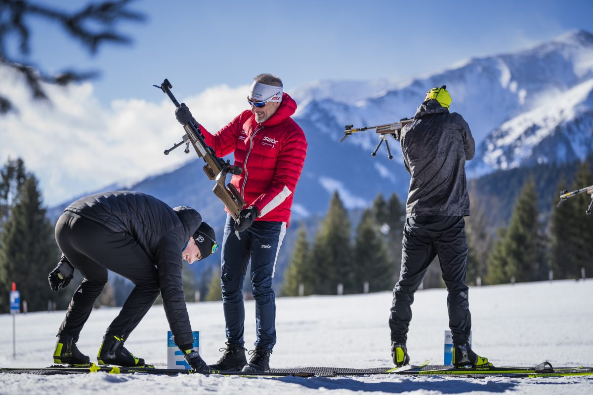 Ernst Reiter betreut zwei Teilnehmer beim Winterbiathlon am Schießstand im Schnee
